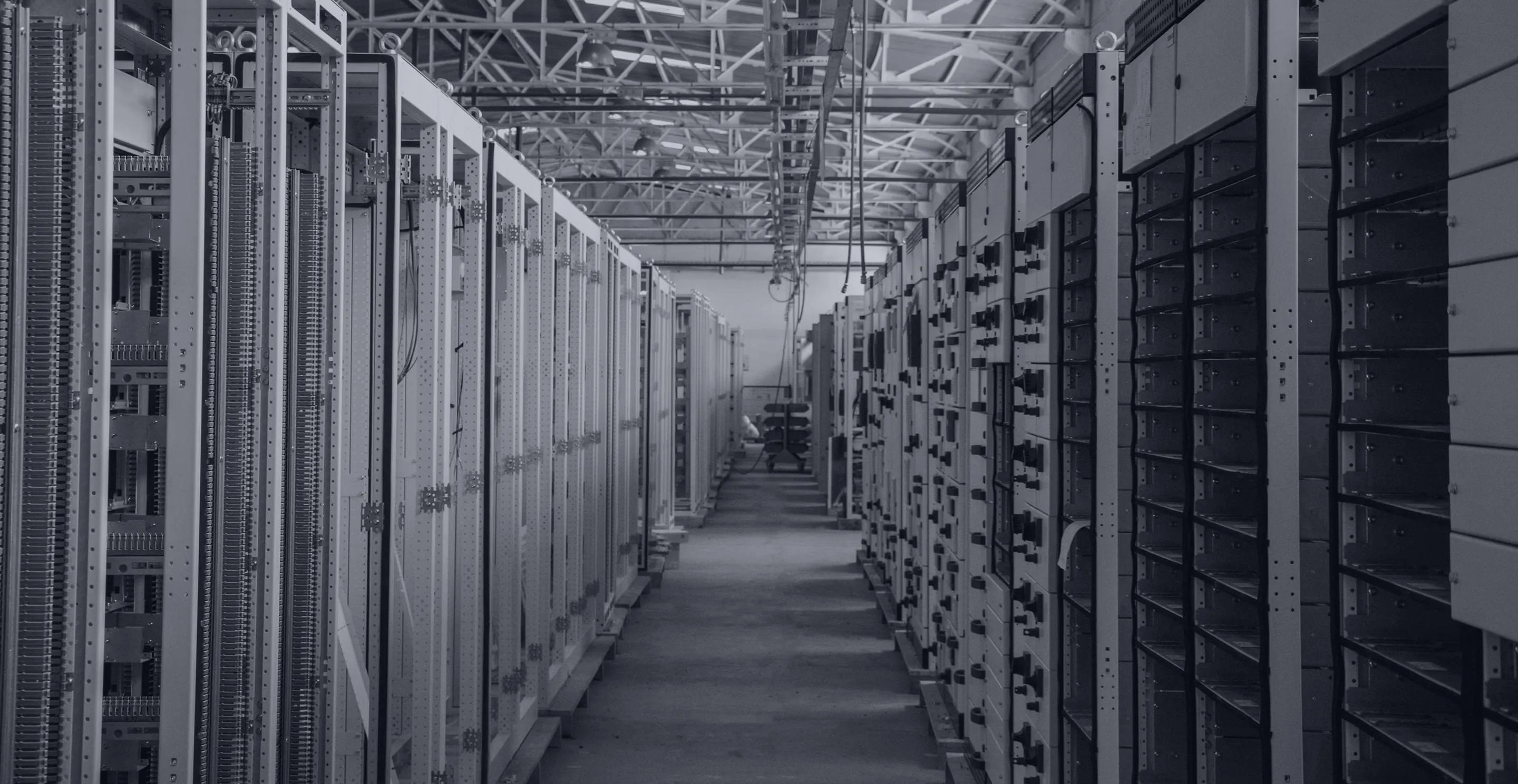 Aisle of electrical switchgear cabinets inside a power infrastructure hall